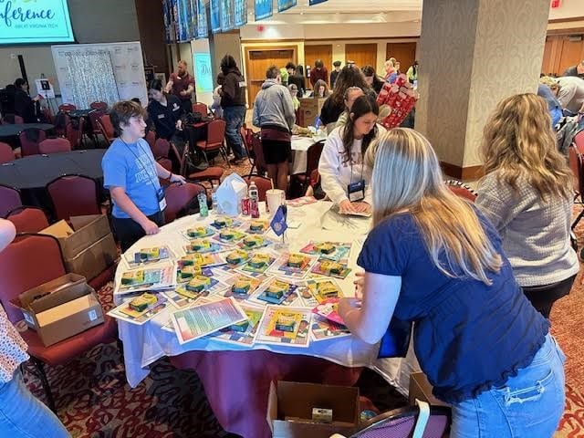 Interact students wrap books during the 2024 district conference.